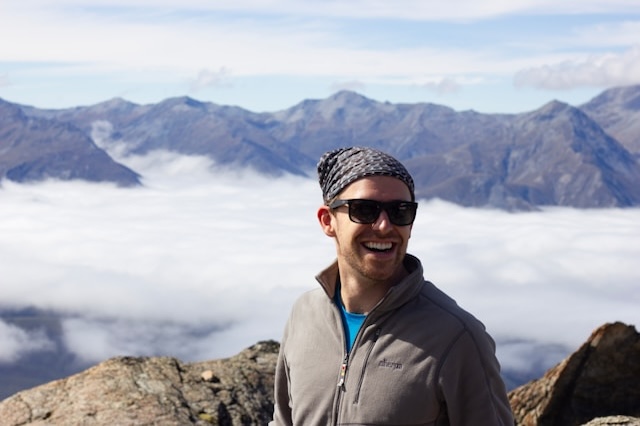 photo of man smiling on a peak